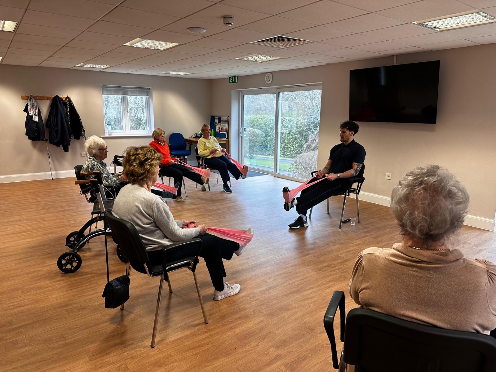 Care-home residents taking part in a seated resistance-band exercise class